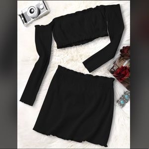Black crop top with matching mini skirt.